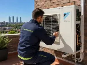 Técnico de Climatermia instalando unidad exterior de bomba de calor Daikin Altherma en terraza de vivienda con skyline de Madrid al fondo