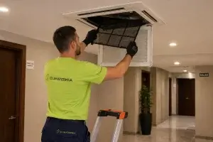 Técnico de Climatermia realizando mantenimiento de aire acondicionado en zona común de comunidad de propietarios en Madrid