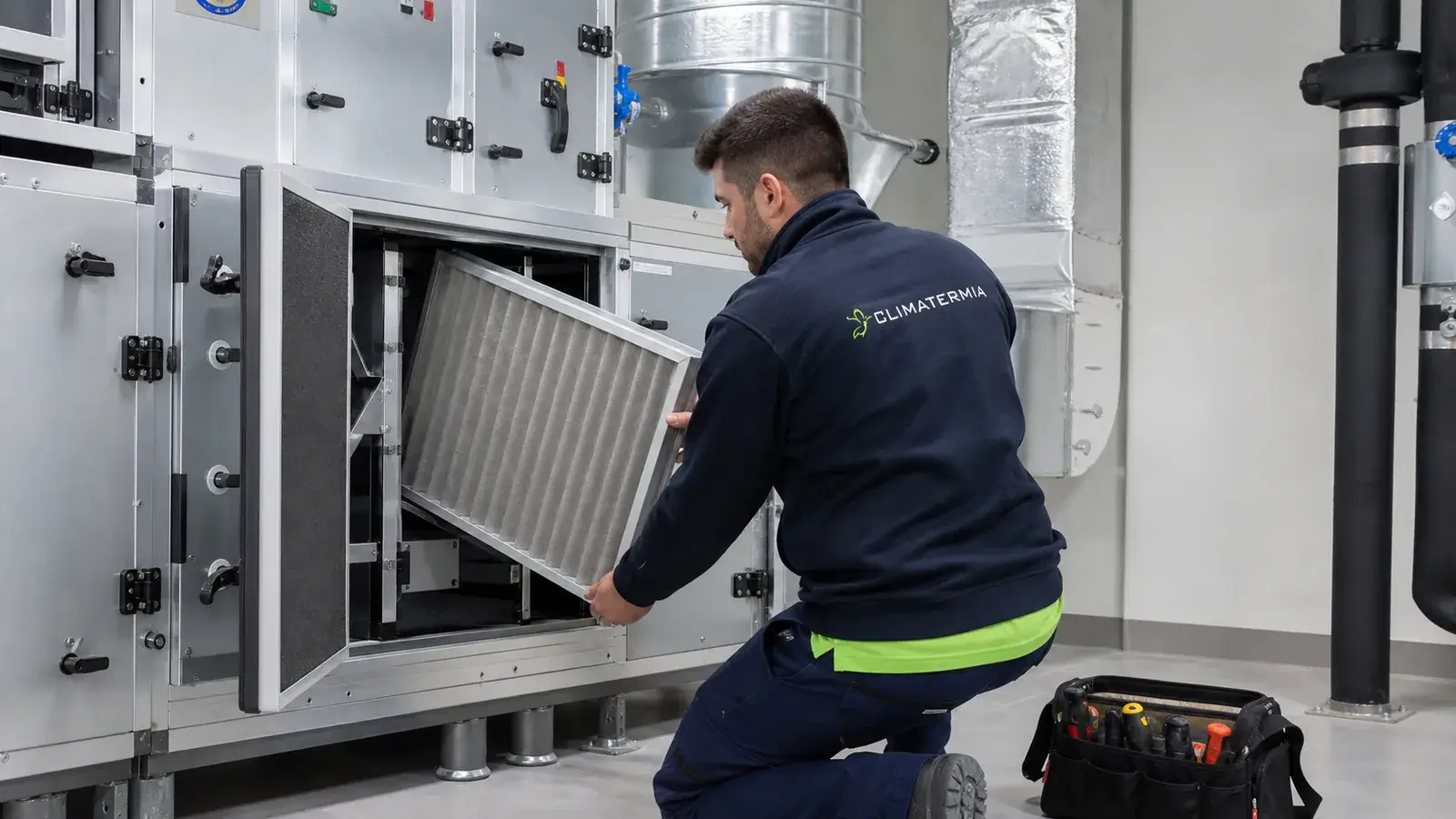Técnico de Climatermia revisando los filtros de una unidad de ventilación escolar