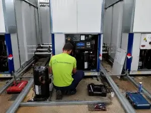 Técnico de Climatermia sustituyendo el compresor de una bomba de calor Carrier AquaSnap averiada por ciclos cortos