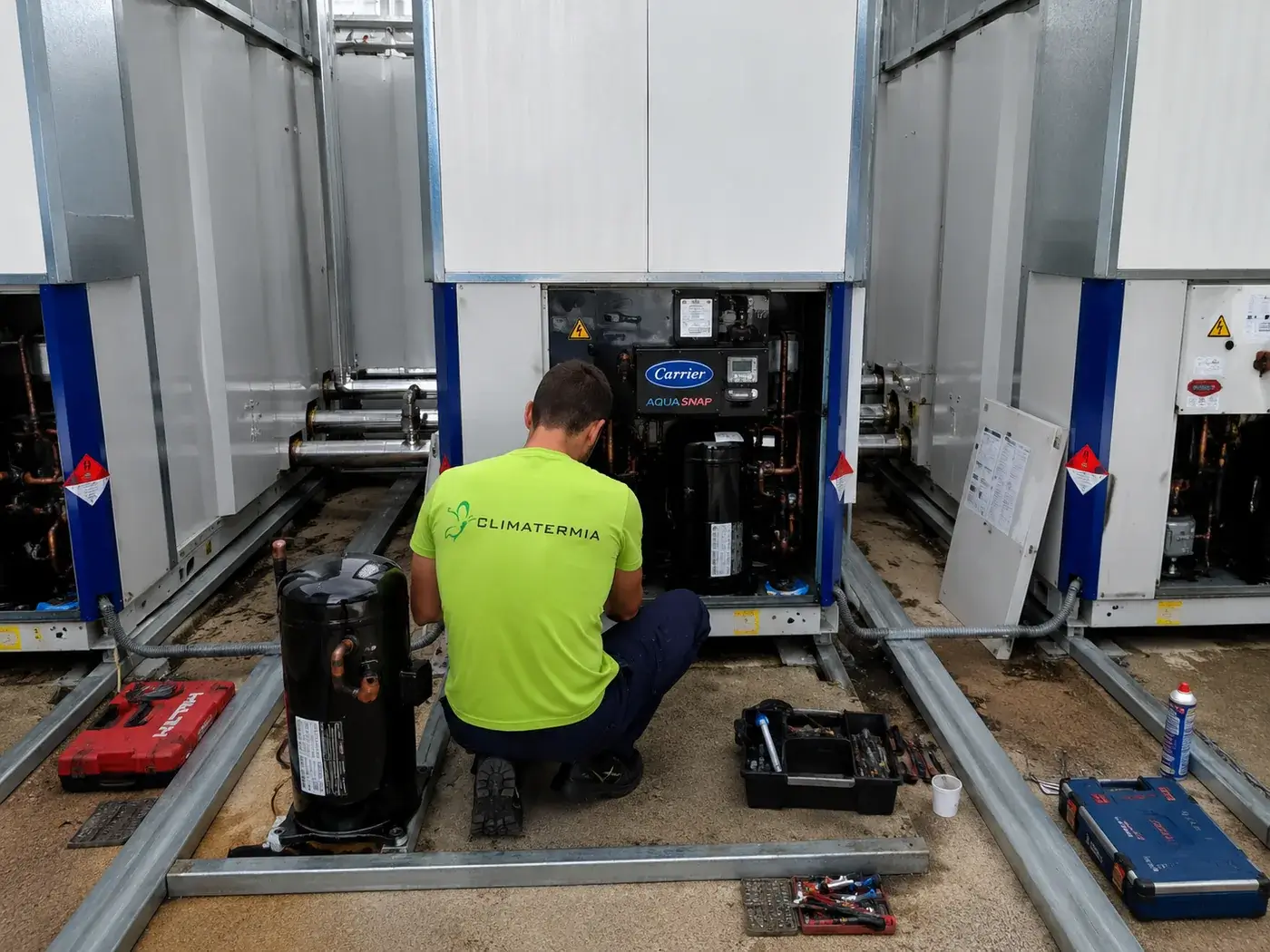 Técnico de Climatermia sustituyendo el compresor de una bomba de calor Carrier AquaSnap averiada por ciclos cortos